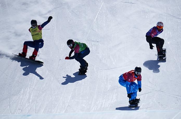 Four Para snowboarders are in action, competing in a line at Beijing 2022