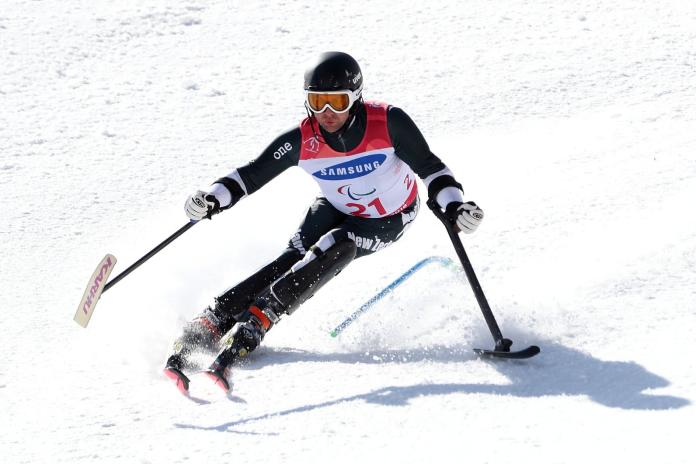 Male Para alpine skier, doing turns on his skis, during competition race