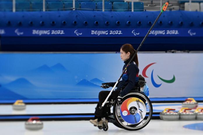 A female wheelchair curler stares ahead