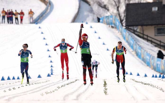Five male skiers approach the finish line