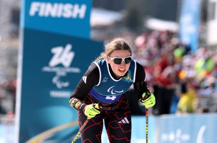 A female Para cross country skier moving forward during compeition
