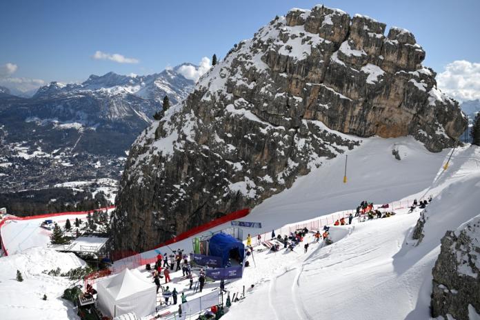 A photograph of Para alpine skiers training on the ski slope, surrounded by mountains