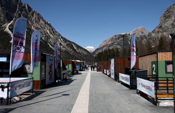Paralympic village, surrounded by mountains and with small wooden houses, with each one having a flag