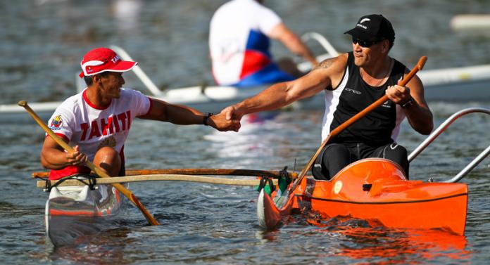 A photo of 2 men in a canoe shaking hands to celebrate a victory
