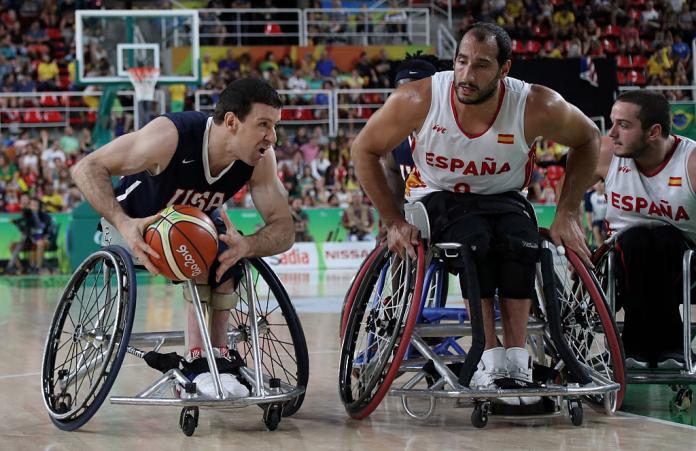 Two men in wheelchairs on the basketball court