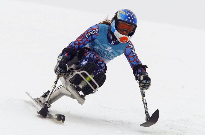 a para alpine skier skies down a slope