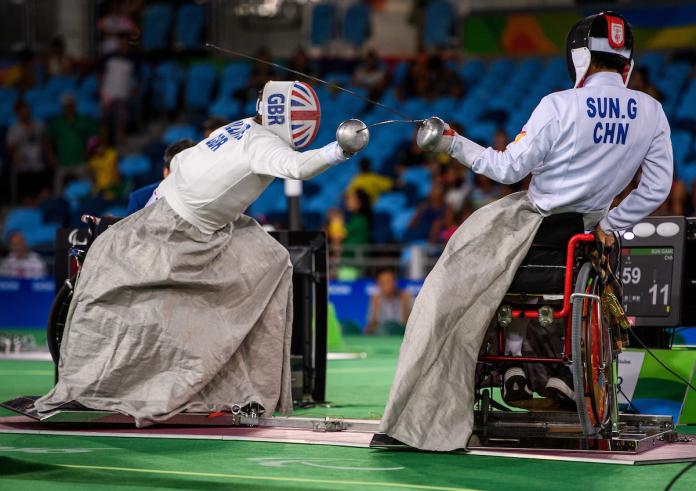 two wheelchair fencers mid bout