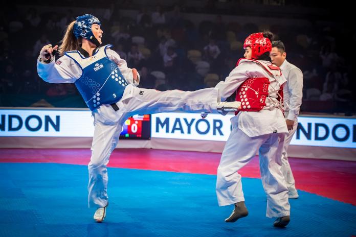 two female Para taekwondo fighters kick at each other