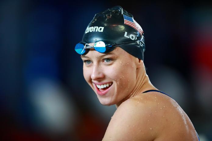 a female Para swimmer smiles after winning her race