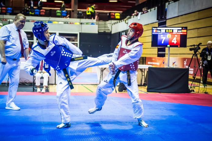 Two male taekwondo athletes fight