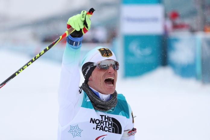 a male Para sit skier punches the air