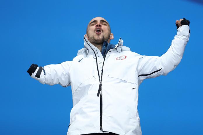 a male Para snowboarder punches the air