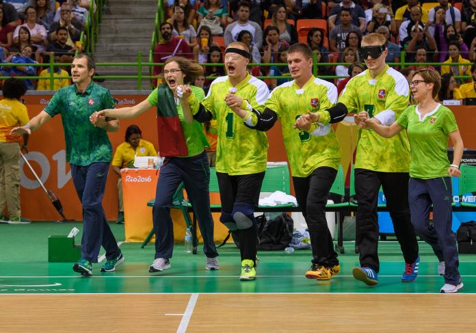 a group of goalball players tie their arms to celebrate