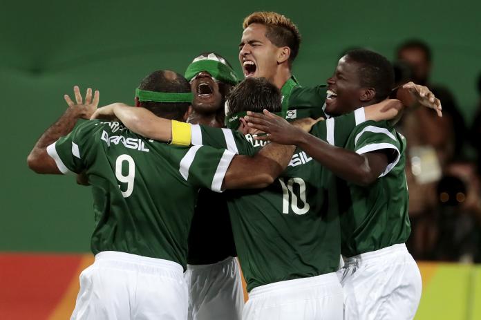 Five Brazilian blind football players celebrating