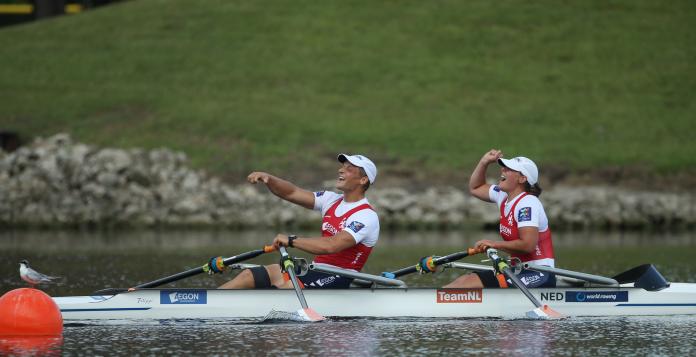 a male Para rower Corne De Koning and female Para rower Annika van der Meer celebrate in their boat