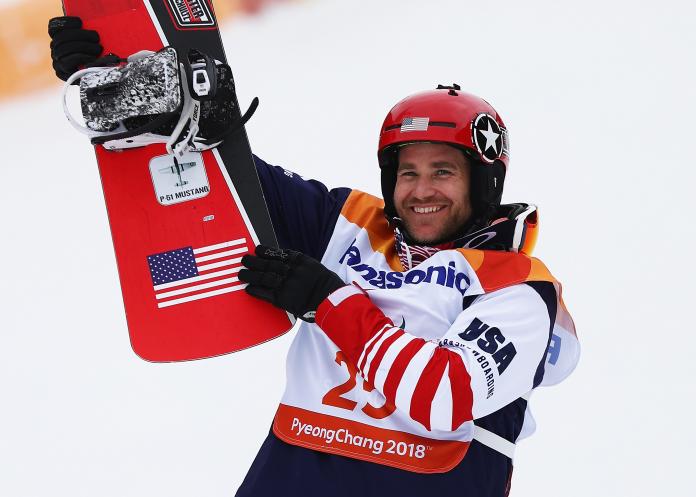 male Para snowboarder Mike Schultz holding up his snowboard