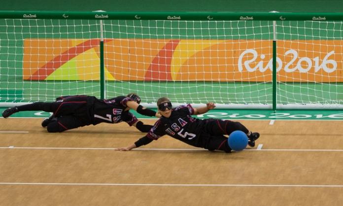 female goalball players Eliana Mason and  Amanda Dennis dive to stop the ball 