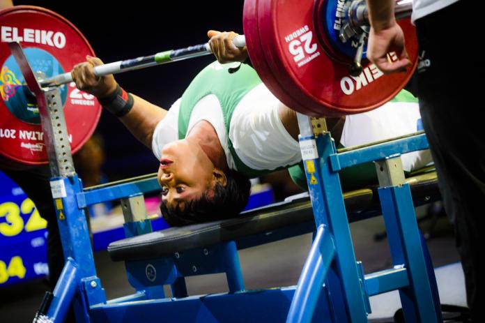 Nigerian powerlifter Bose Omolayo stretches on the bench before making her lift