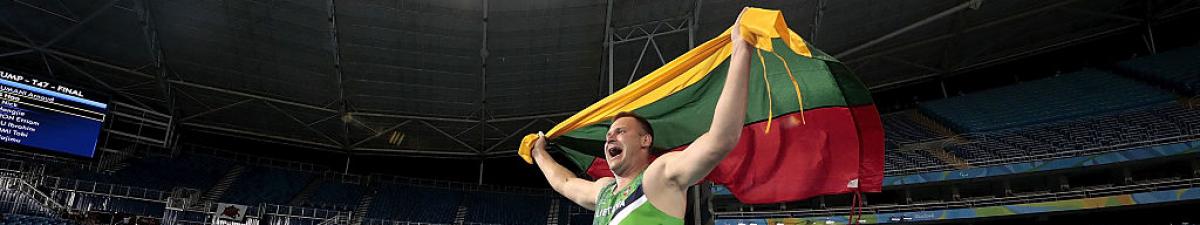 a male athlete celebrates with the Lithuania flag