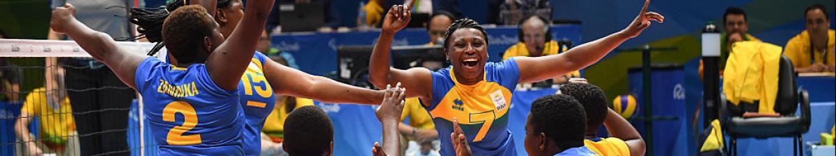 female sitting volleyball players celebrating on the court