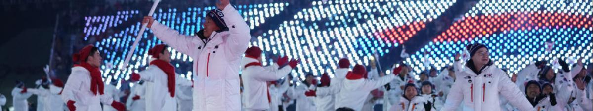 a group of Para athletes walking at an opening ceremony