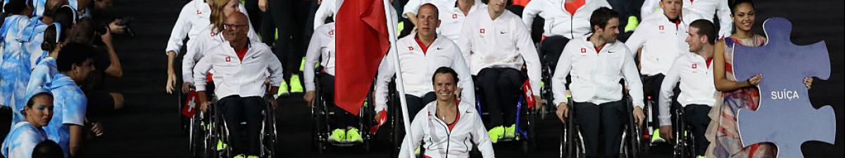 a group of Para athletes walking at an opening ceremony