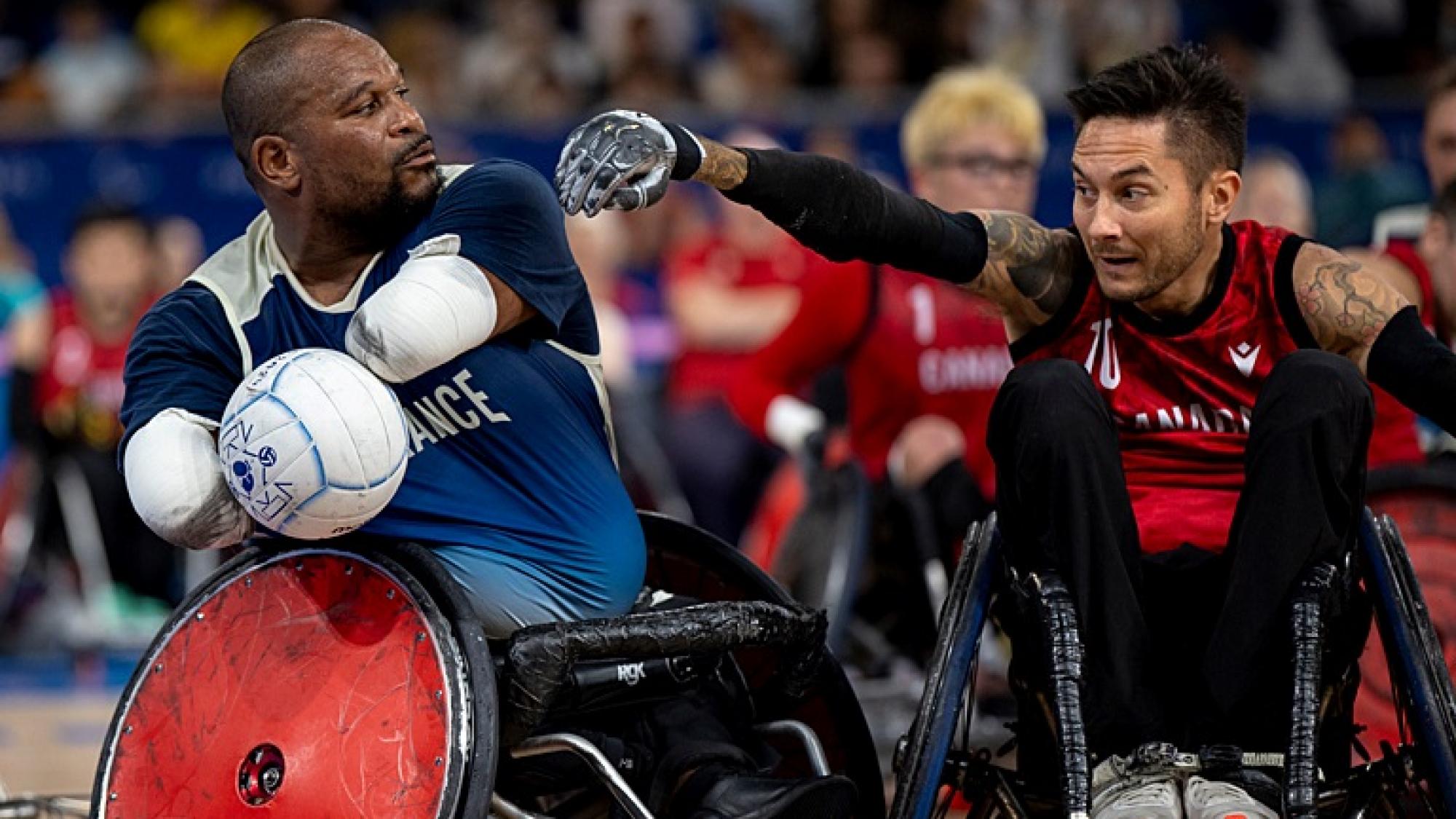 Two male wheelchair rugby athletes in competition. 