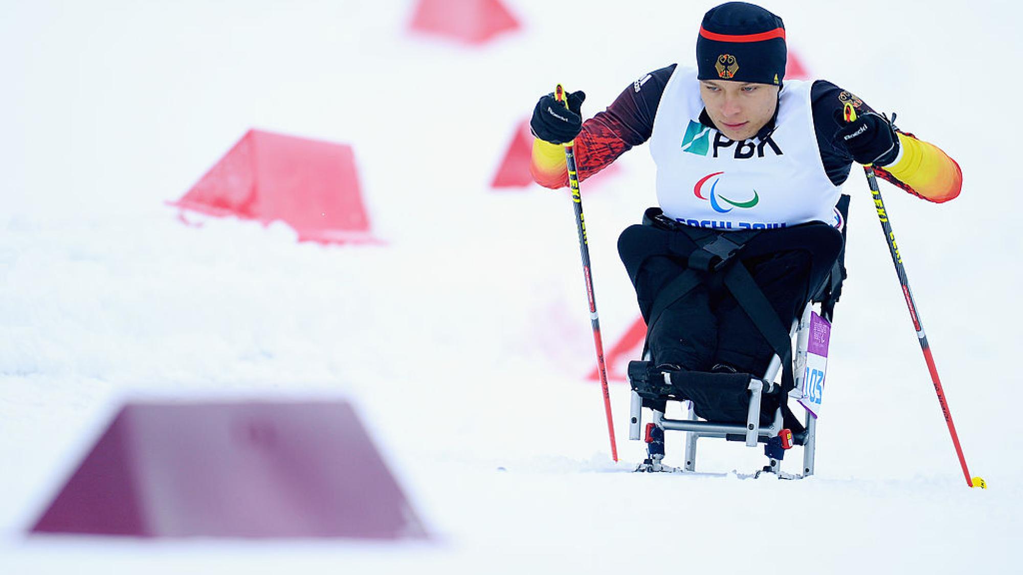 A female sit-skiing athlete is competing 