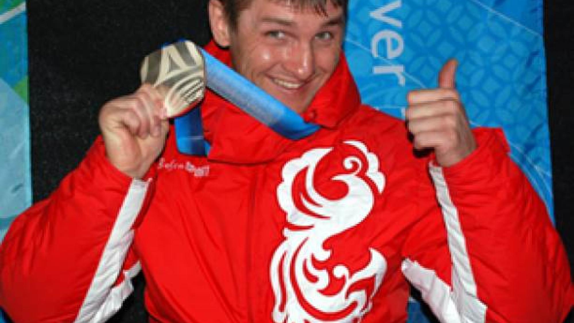 A picture of a man in equilibrium on his wheelchair during a medal ceremony