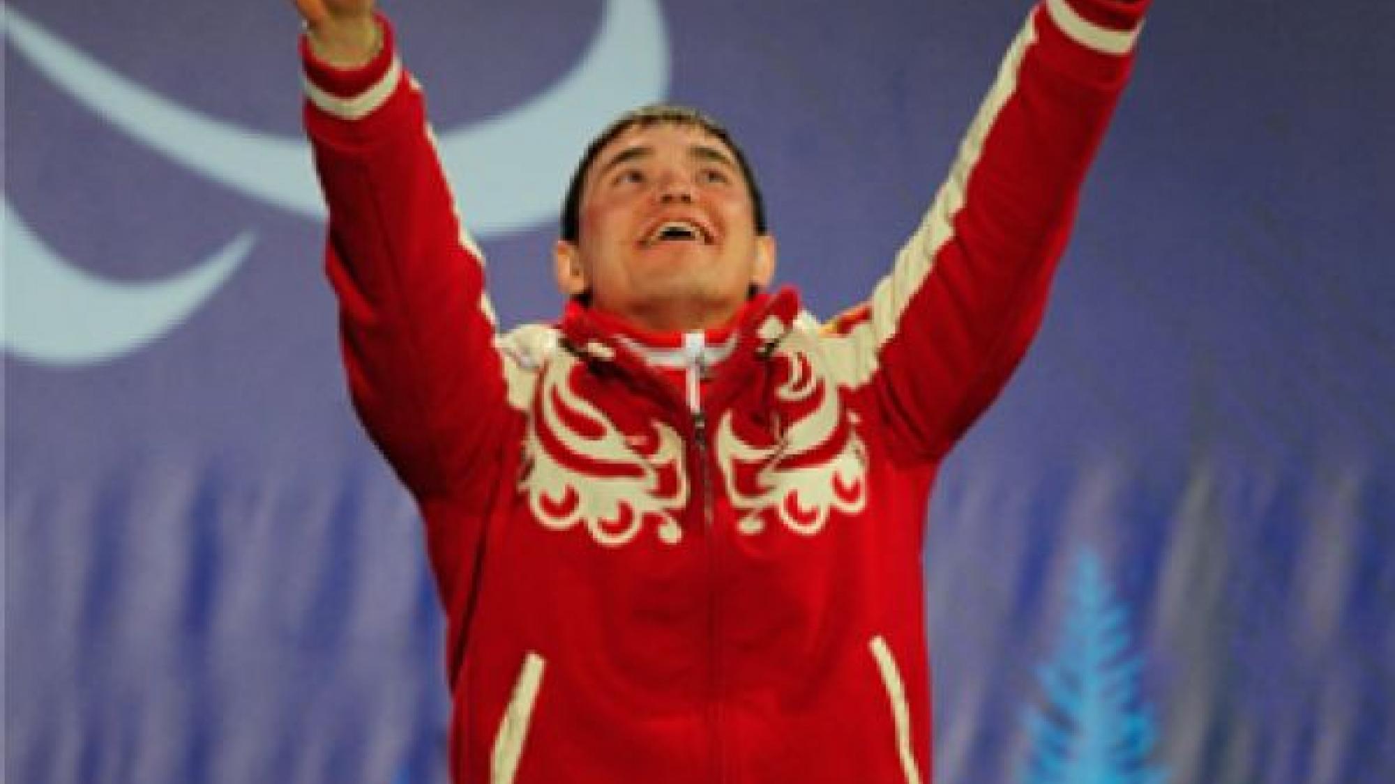 A picture of a man in a wheelchair celebrating his victory during a medal ceremony