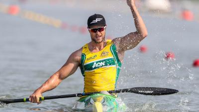 Man in kayak splashes water to celebrate victory