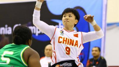 Chinese woman in wheelchair about to shoot basketball