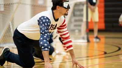 Male goalball player touches the floor to orient himself