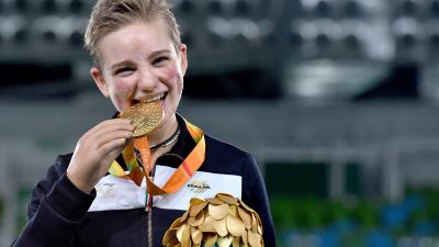 Young woman shows a medal and smiles