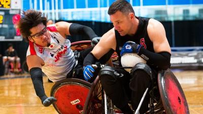 male wheelchair rugby player Daisuke Ikezaki tackles another player