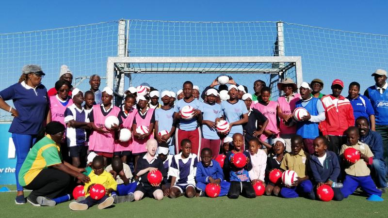 Kids pose for the photo in the blind football field