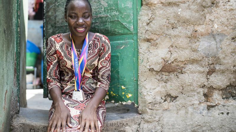 Angolan sprinter Esperanca Gicasso poses for a picture in front of her house with the two medals she won at the London 2017 World Para Athletics Championships