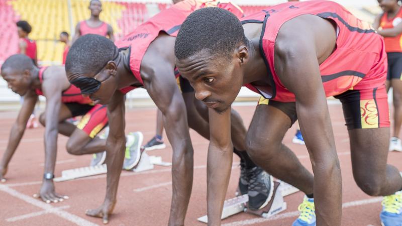 Athletes and guides prepare in starting blocks during Agitos Foundation training camp in Luanda