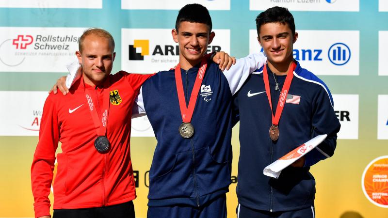 Three young men on a podium with their medals