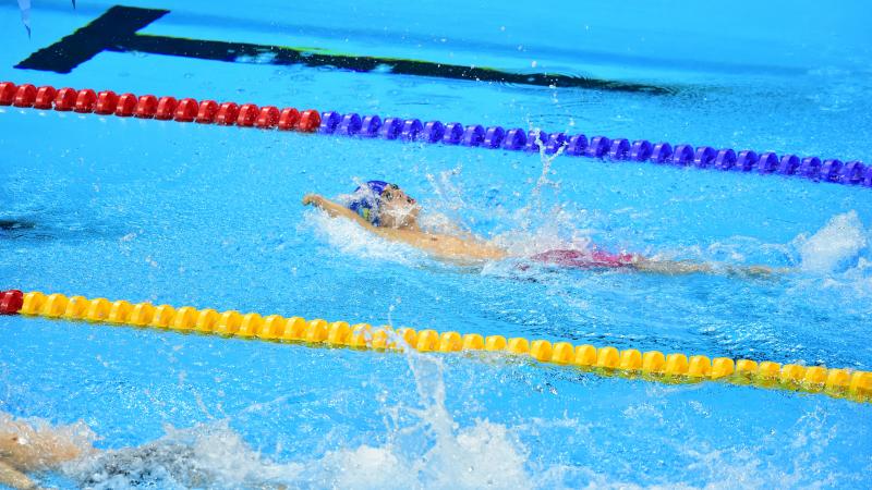 a male Para swimmer competing in a backstroke race