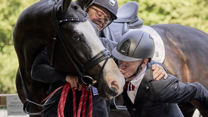 Man kisses his horse on the nose