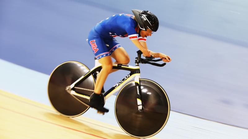 Woman riding track bike in velodrome 