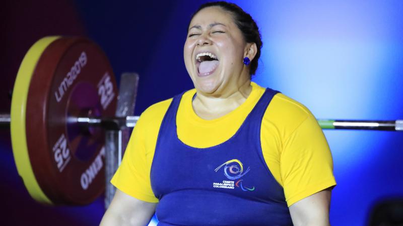 a female powerlifter celebrates on the bench