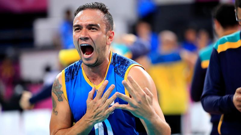 male sitting volleyball players celebrate on the court