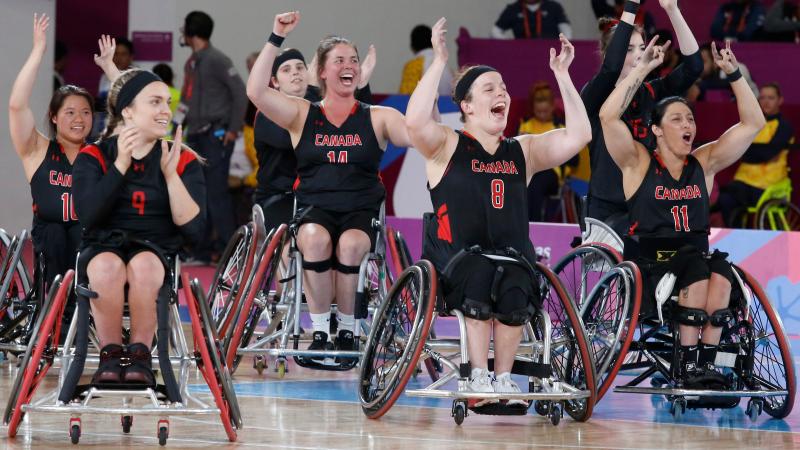 a group of female wheelchair basketball players cheering