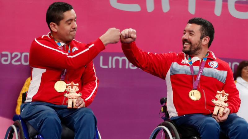 two male wheelchair table tennis players bump fists
