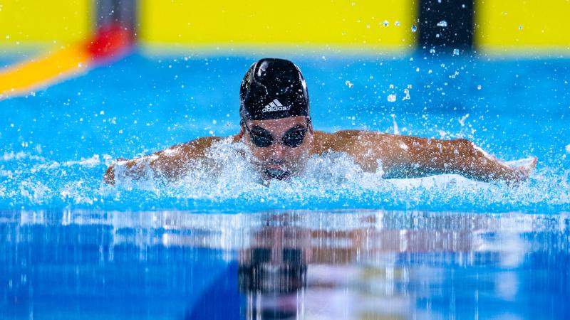 a male Para swimmer doing a butterfly stroke in the pool