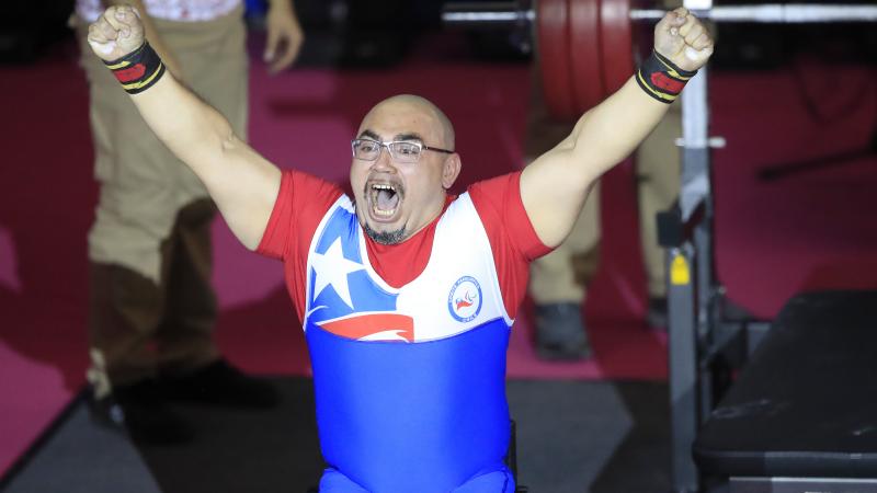 a male powerlifter celebrates on the bench