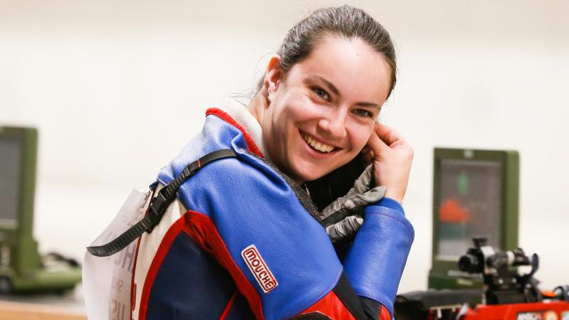 female Para shooter smiles at the camera