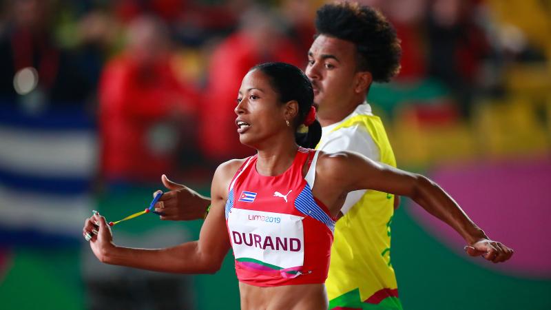 a female vision impaired runner and her guide running on the track